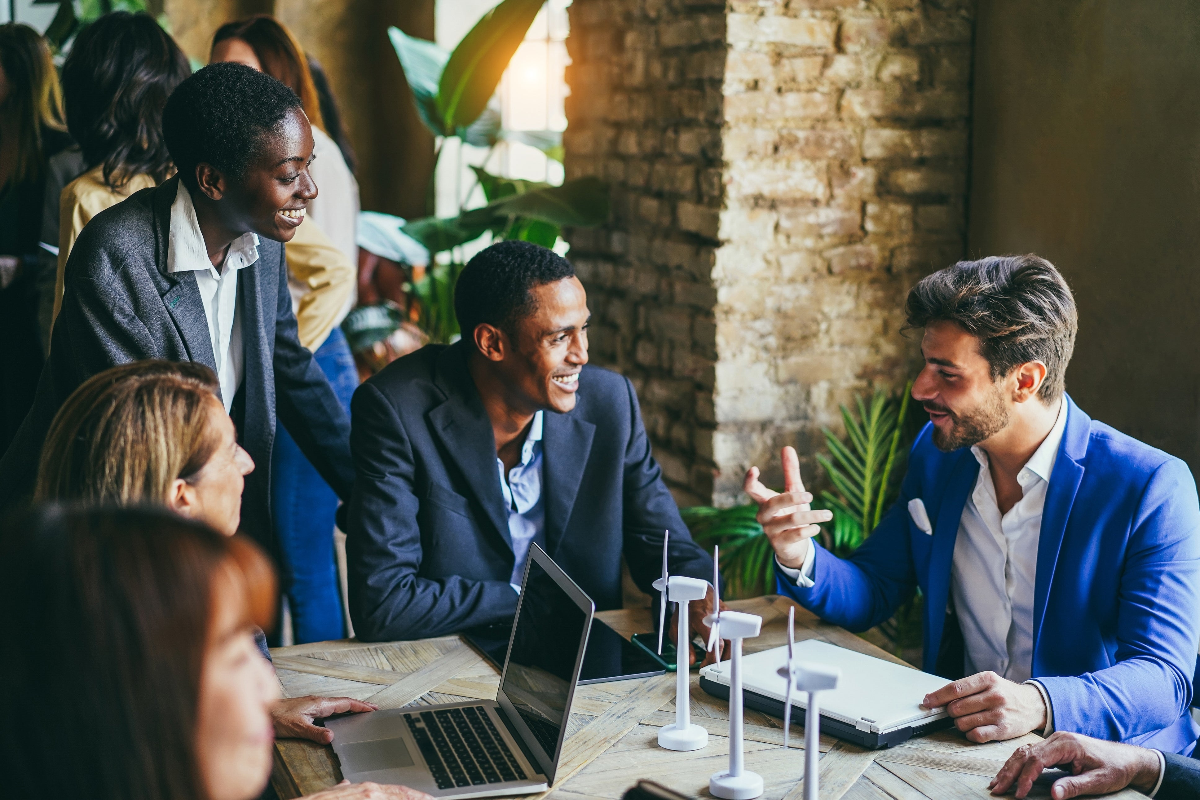 People discussing around a table with laptops