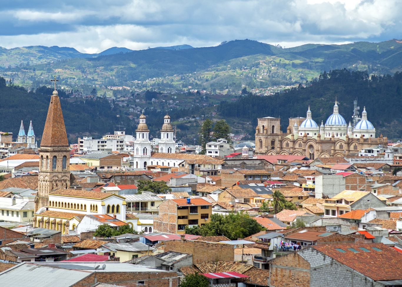 View of a city in the mountain with tiled roofs and many church towers