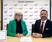 Lori and Omar smiling during signing ceremony