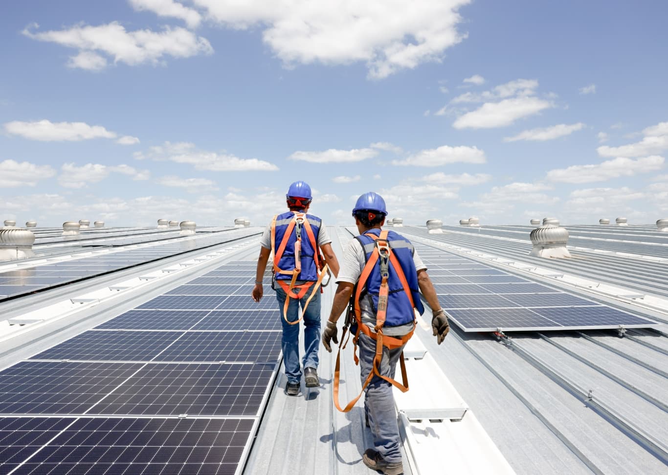 Deux hommes marchant sur un toit de panneaux solaires