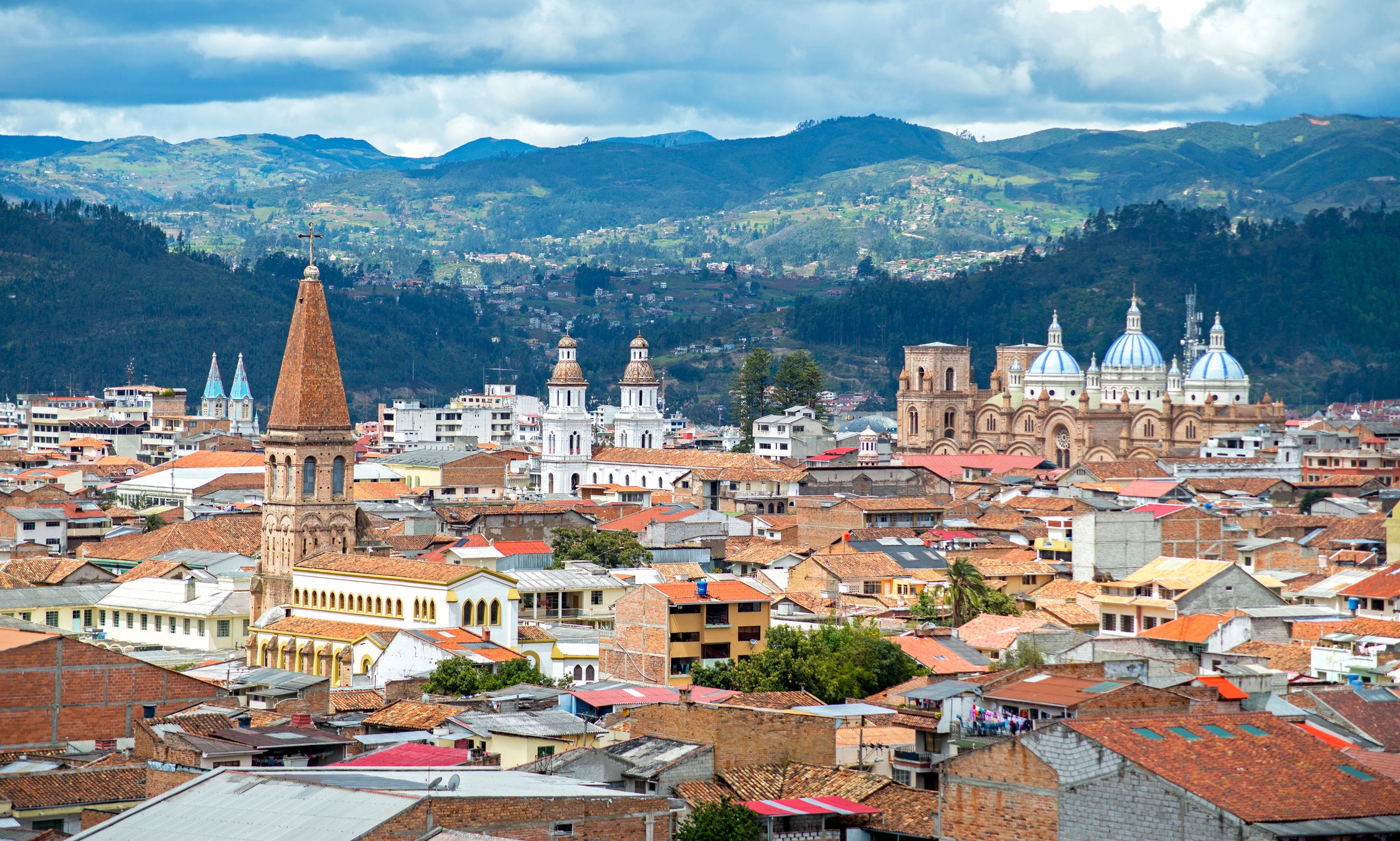 View of a city in the mountain with tiled roofs and many church towers