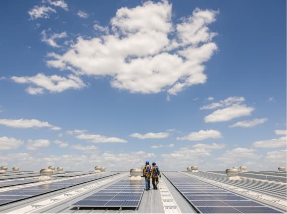 Two men walking on a solar paneled roof