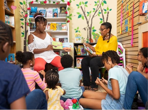 Two women reading to children in a bookstore